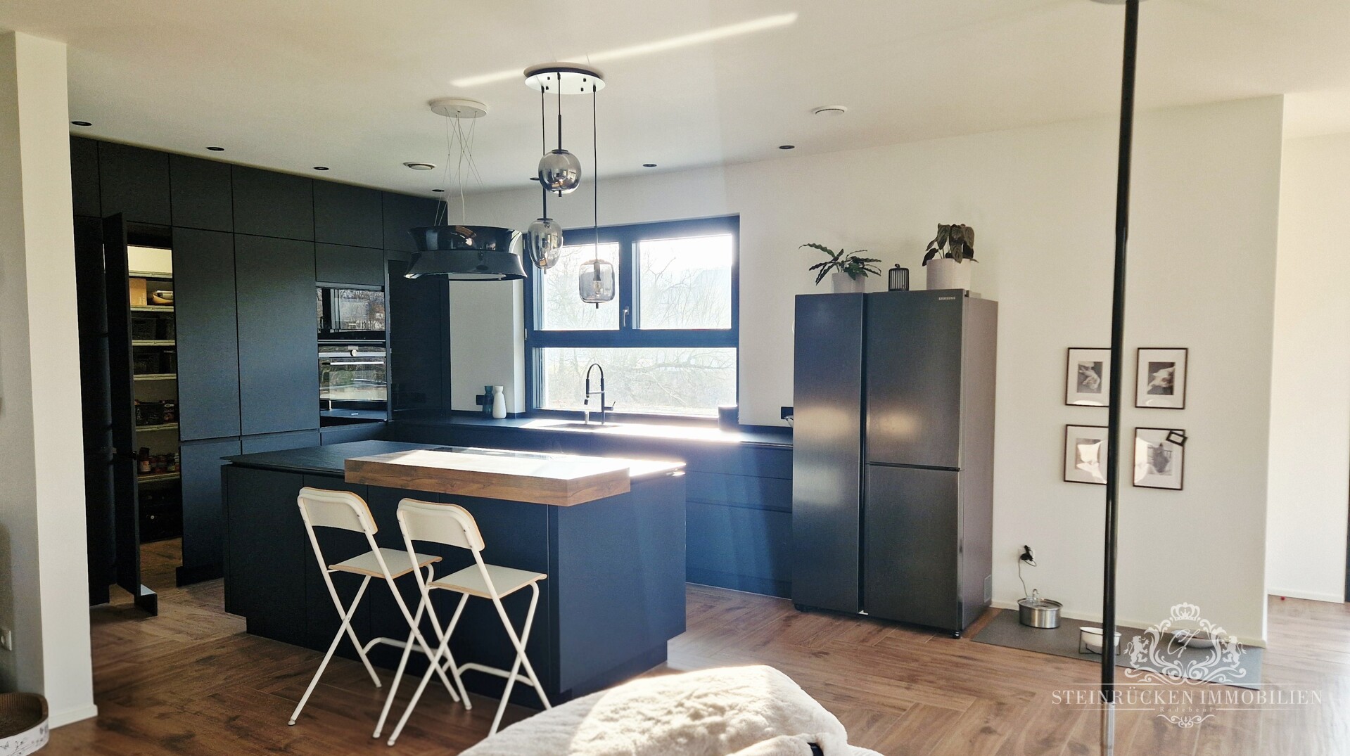 Elegante Premiumküche mit Bar‑Ambiente, großzügiger Kochinsel und verborgener Speisekammer