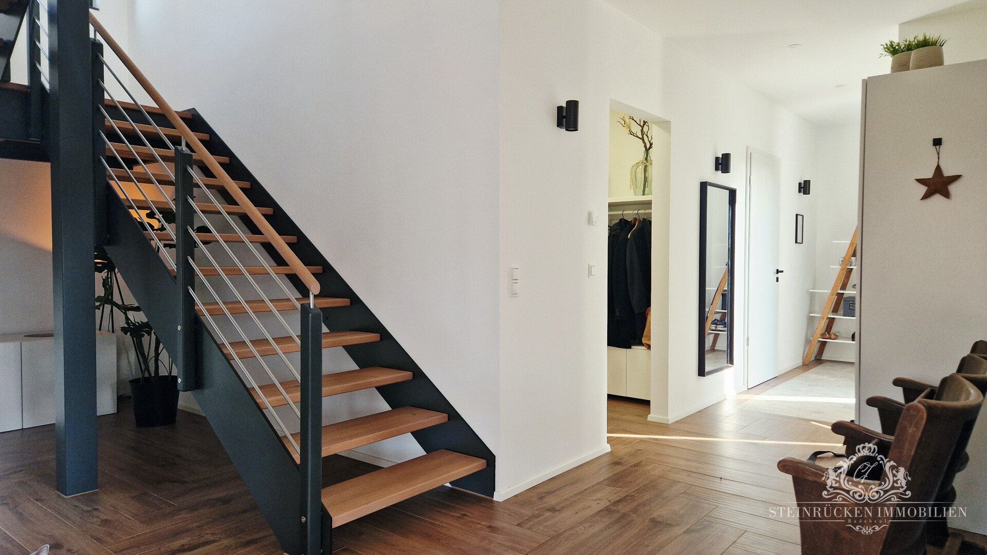 Eleganter Flur mit Design‑Treppe und klaren Linien