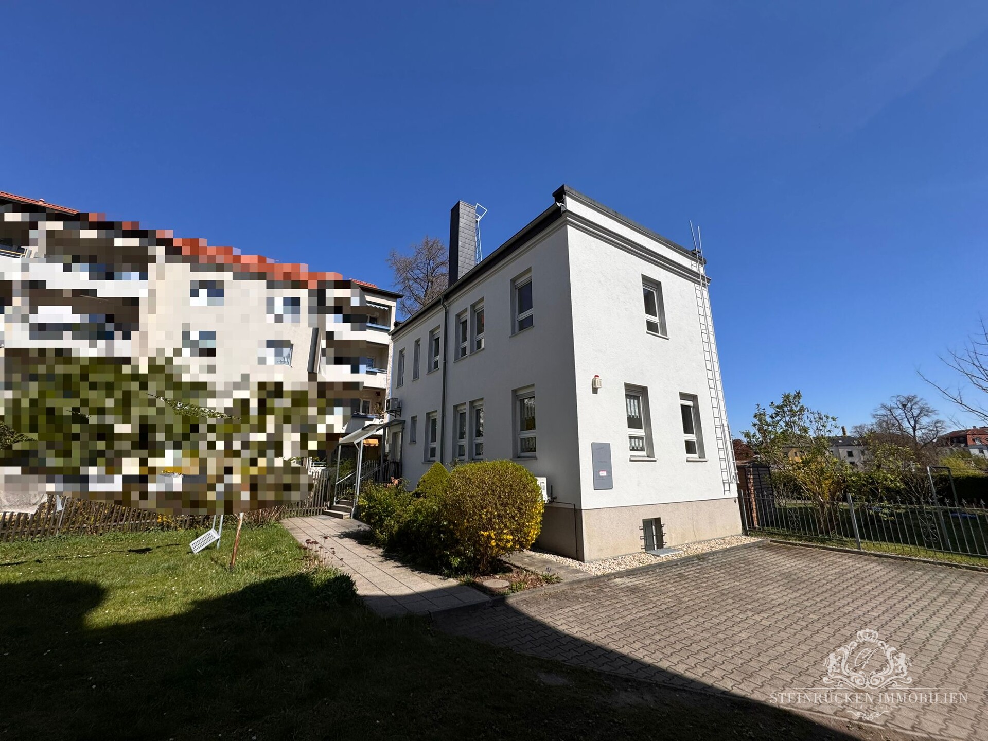 Hausansicht mit angrenzenden Parkplätzen