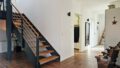 Eleganter Flur mit Design‑Treppe und klaren Linien