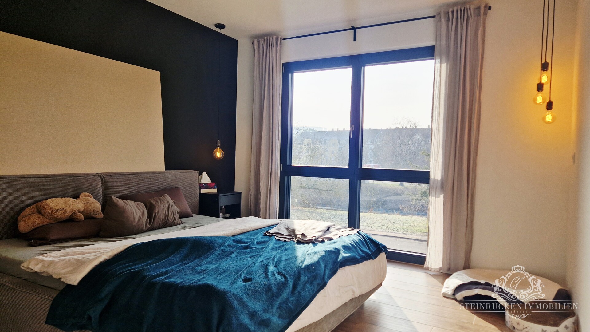 Stilvolles Schlafzimmer mit dunkler Akzentwand und Design‑Beleuchtung
